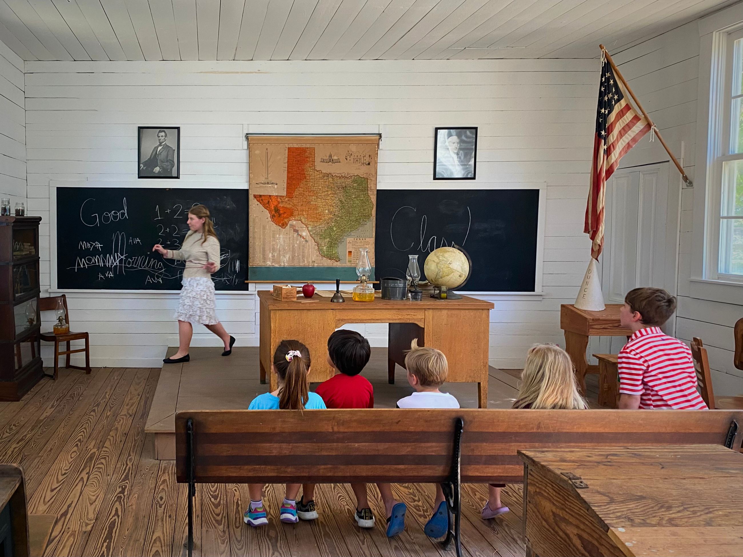 picture of kids learning about the history of one of the first schools in Tomball
