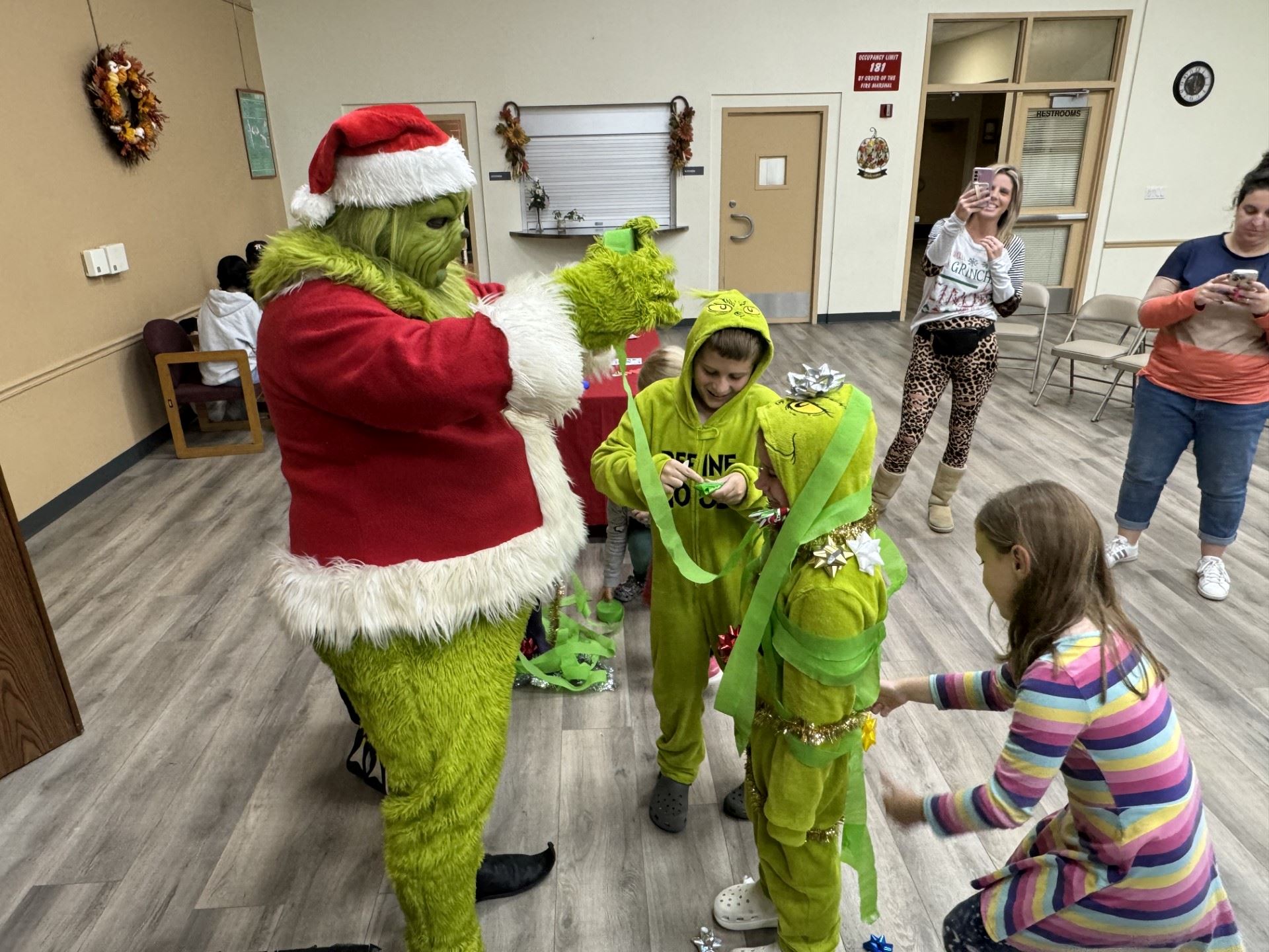 grinch playing tree wrap game with kids