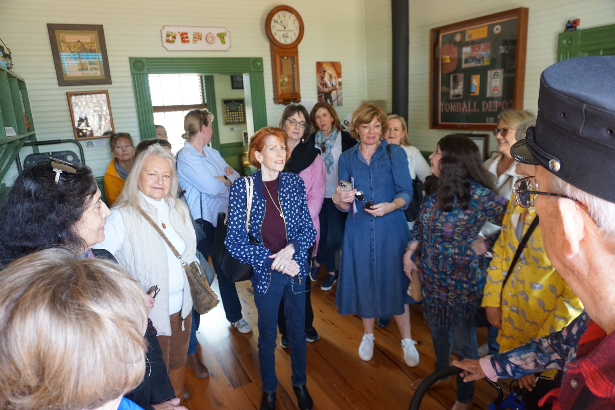 a group of ladies gather to hear railroad stories form lead volunteer John 