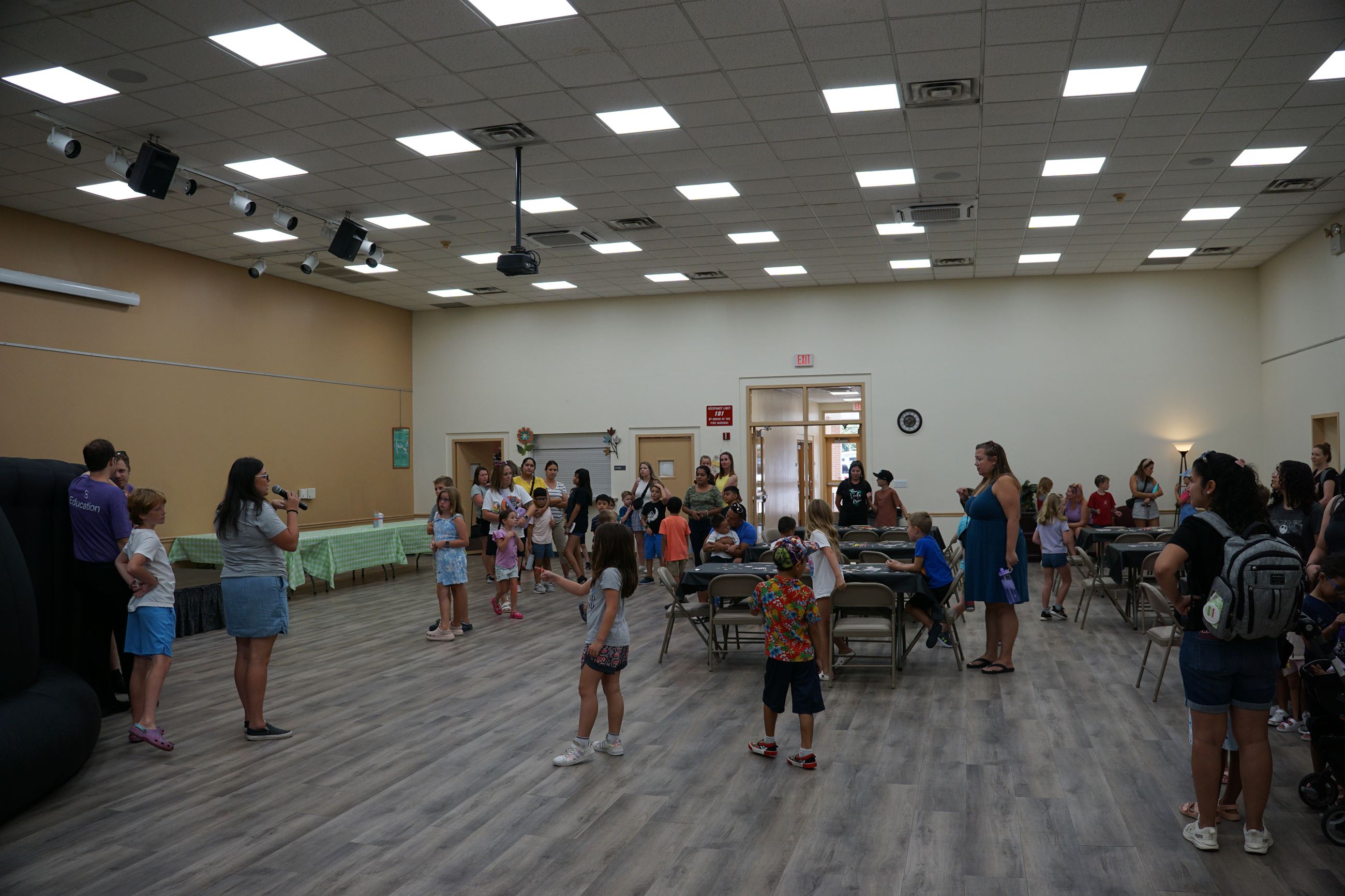 picture of our Kids Club Director welcoming the kids to the final event of the summer