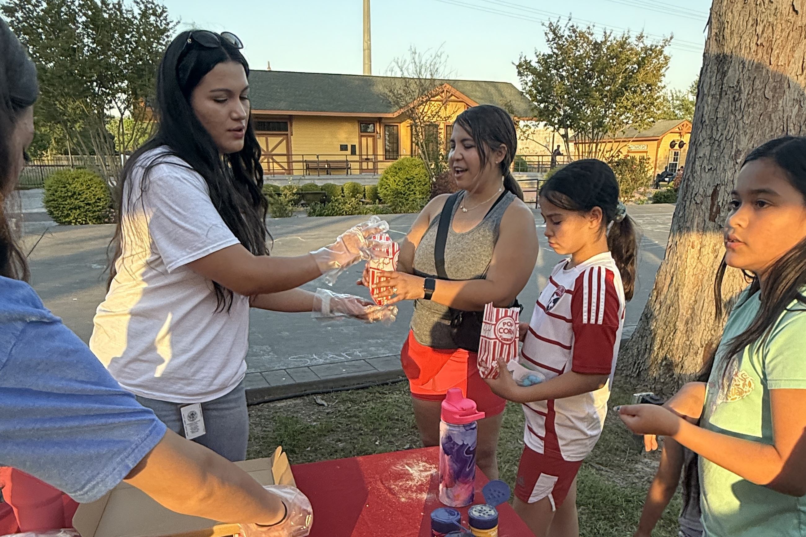 Image of volunteers handing out popcorn at April 2025 2nd Saturday at the Depot