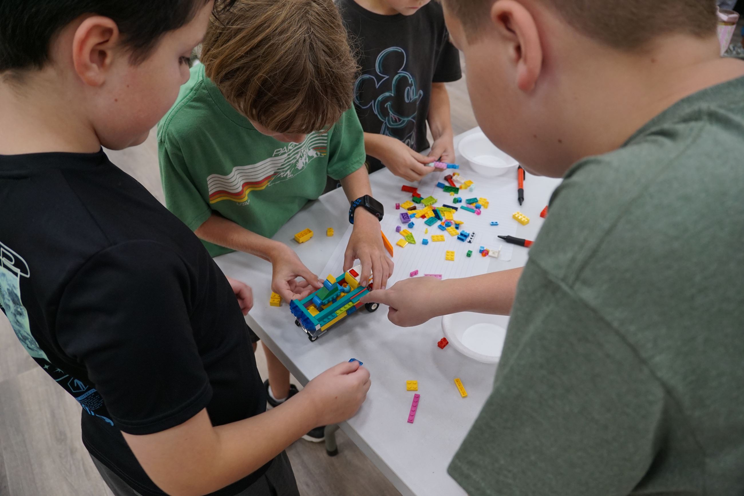 Image of July 2025 Tomball Kids Club participants building LEGO vehicles