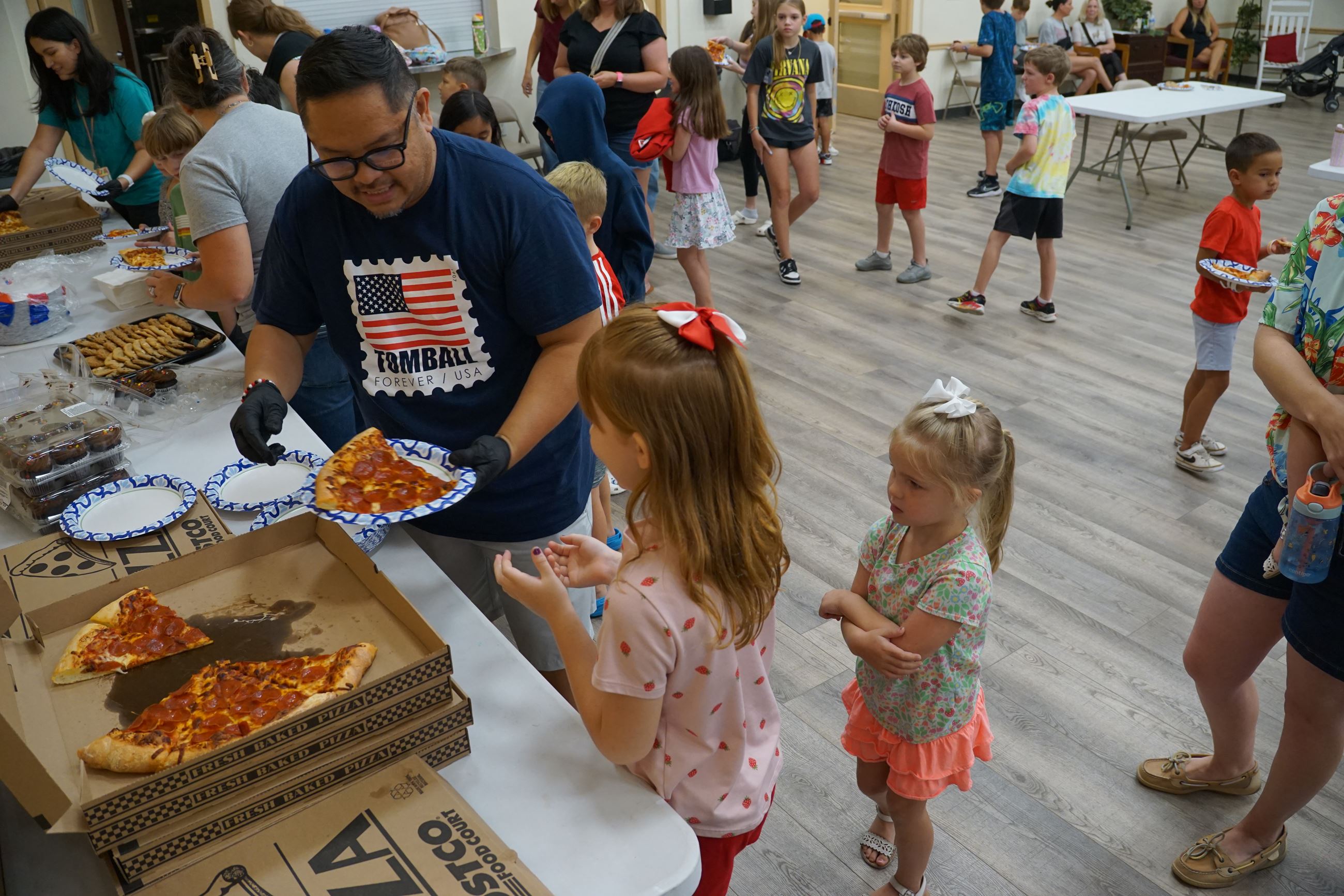 Image of July 2025 Tomball Kids Club participants receiving lunch donated by Tomball Costco