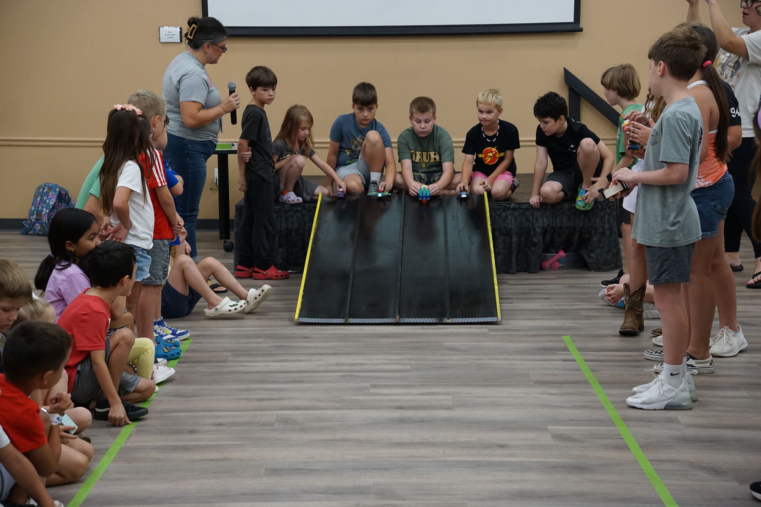 Image of July 2025 Kids Club participants racing LEGO vehicles